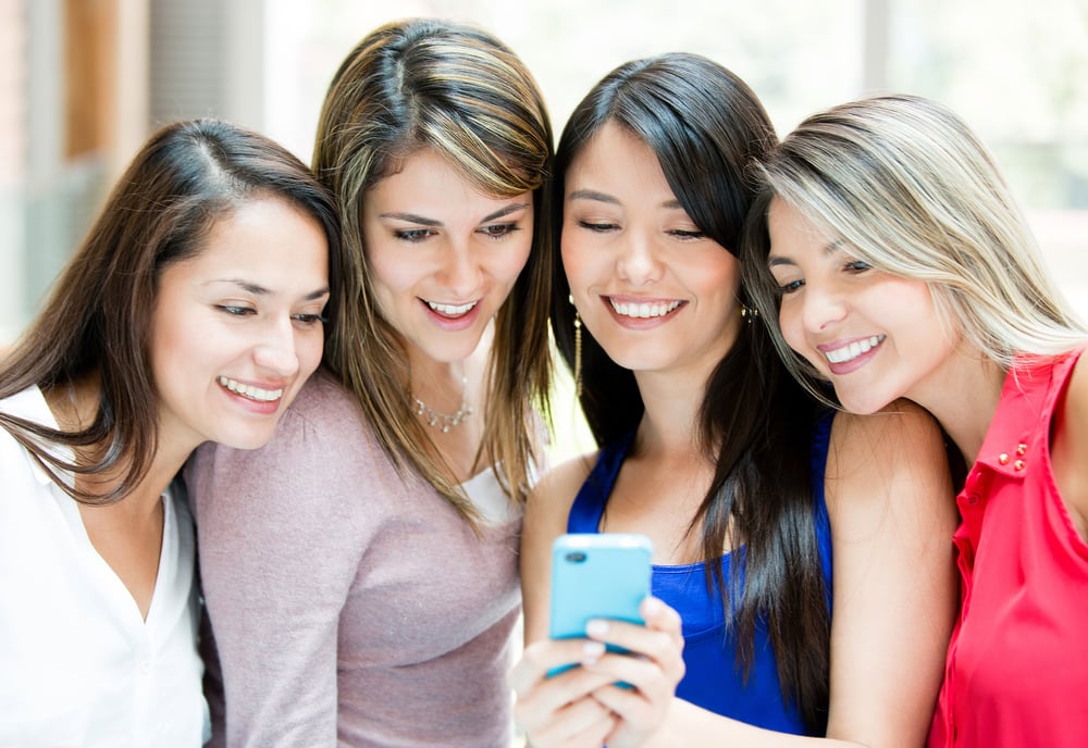 A group of women viewing a redesigned WordPress website on a mobile device